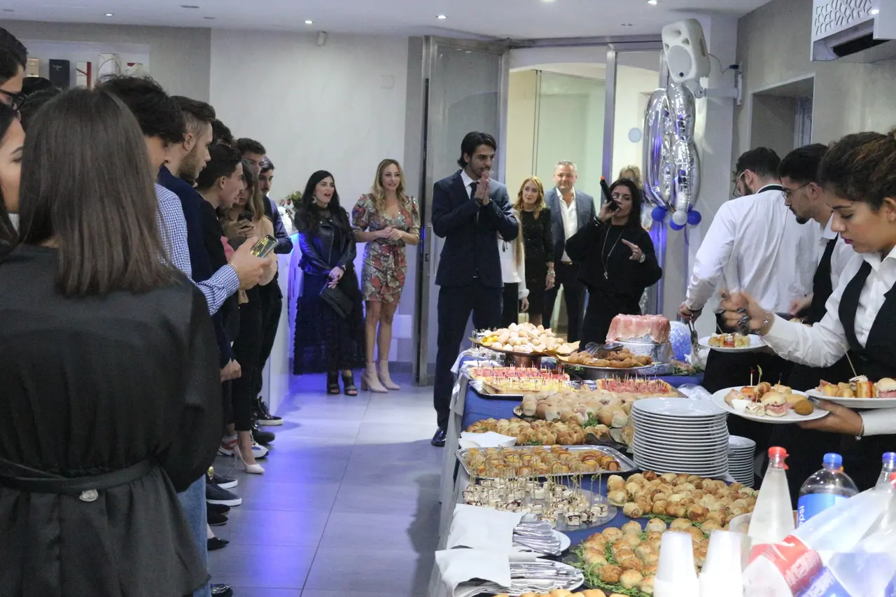 Sala ricevimenti con ospiti e buffet allestito per una festa