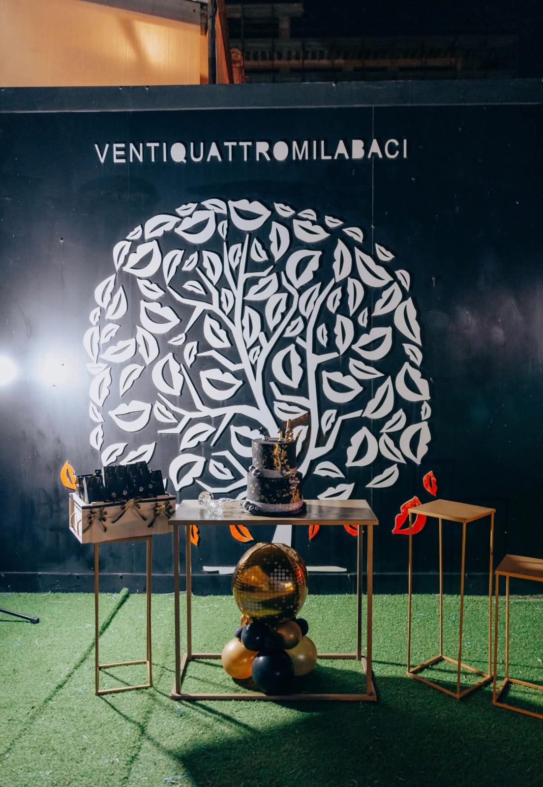 Il muro dell'albero dei baci con la scritta Ventiquattromilabaci e sweet table